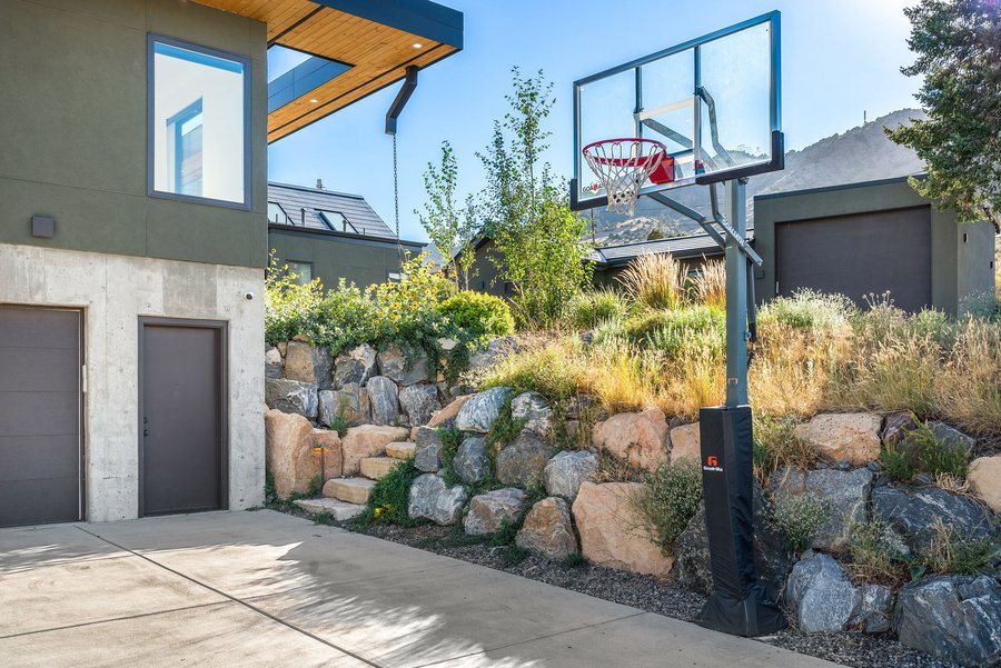 Basketball hoop beside a stacked-boulder wall