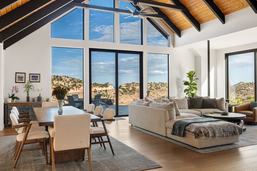 Great room with dining table and sofa facing tall windows