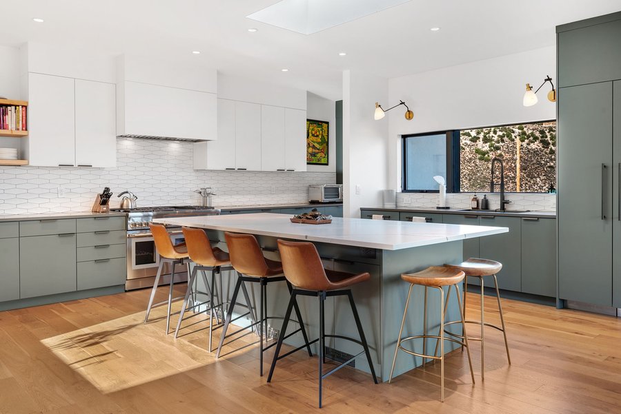 Kitchen island with leather counter stools and a professional range