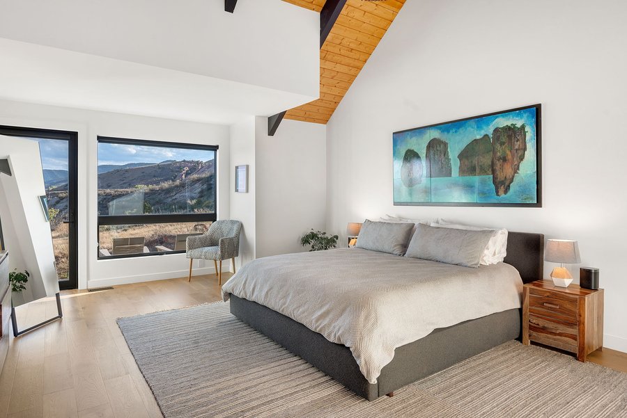 Primary bedroom with a king bed, wood ceiling and mountain views