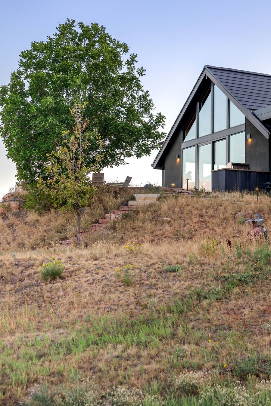 The glass gable of the main house rising above the hillside