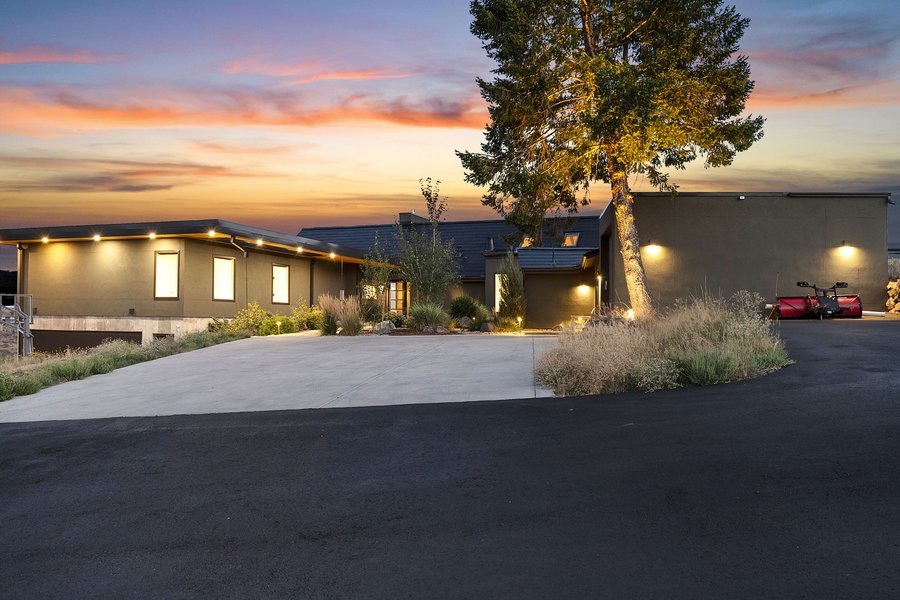 Main house at sunset over the driveway, with the pine tree lit from below
