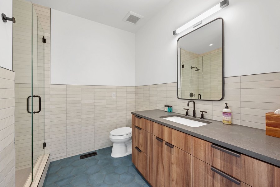 Guest bathroom with a blue floor, a walnut vanity and a glass shower