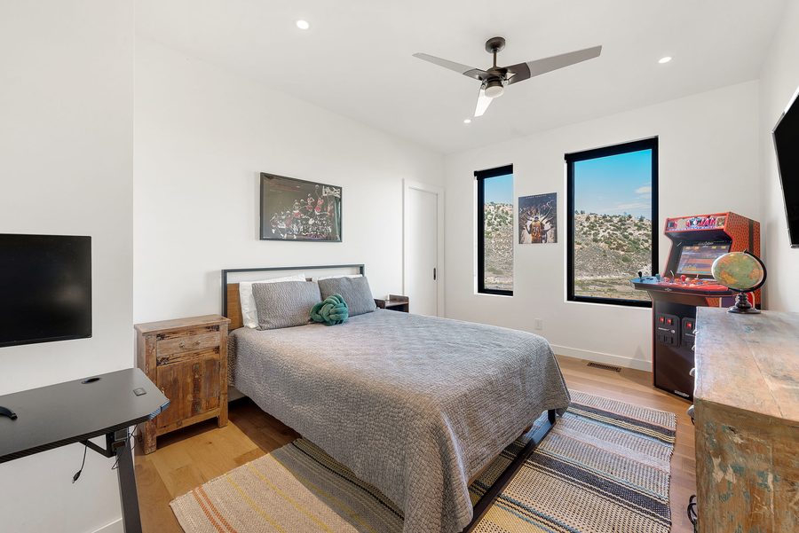 Bedroom with a queen bed, wood nightstand and framed poster