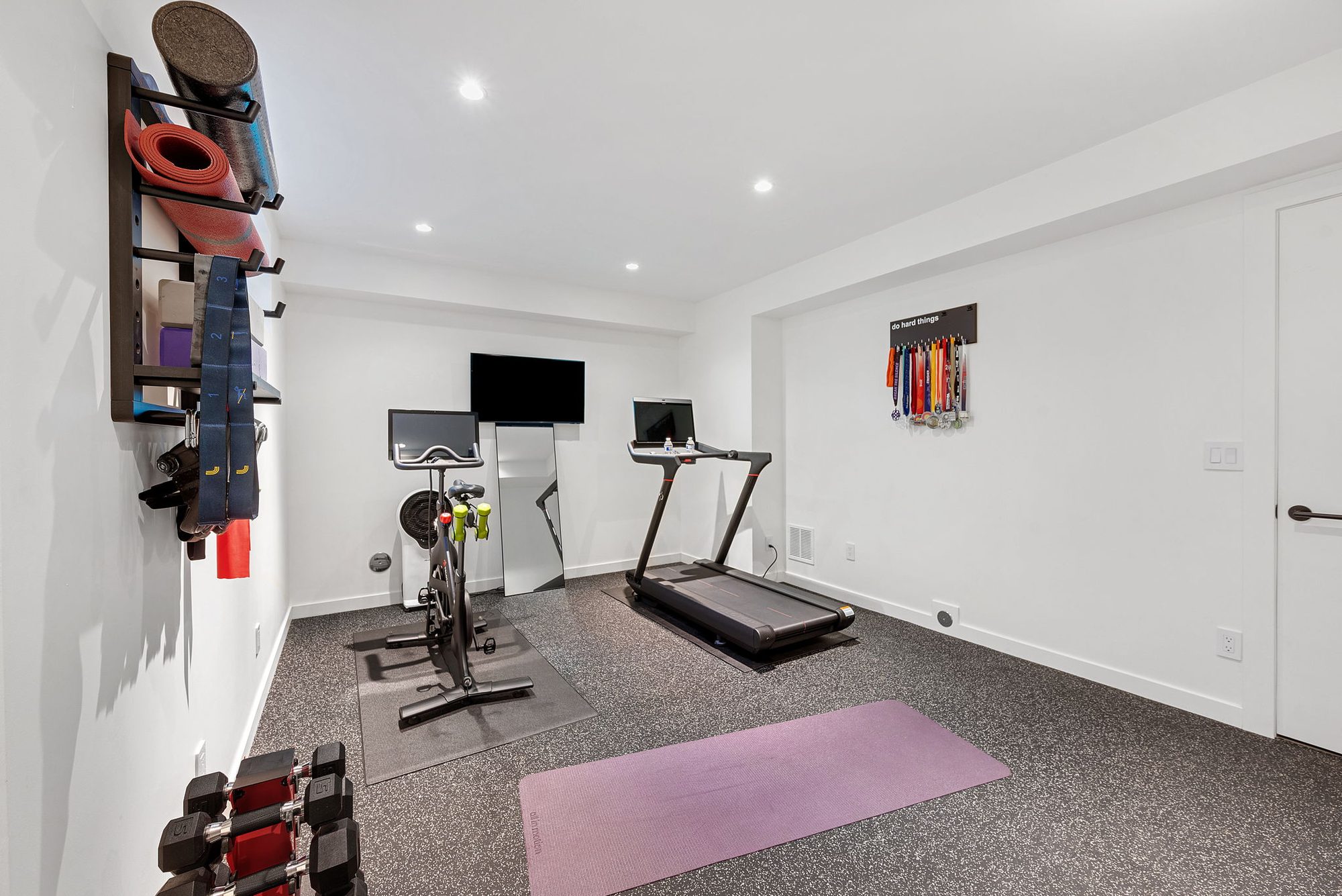 Fitness room with an exercise bike, treadmill and yoga gear