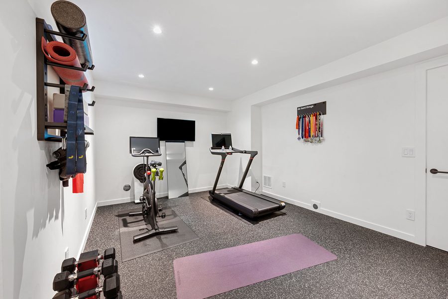 Fitness room with a treadmill, exercise bike and free weights