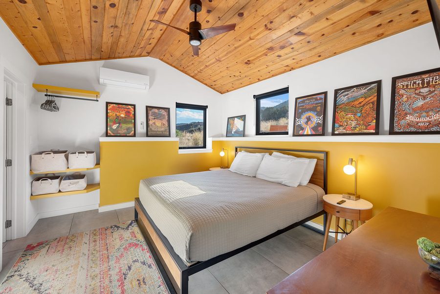 Guesthouse bedroom with a king bed, wood ceiling and framed concert posters