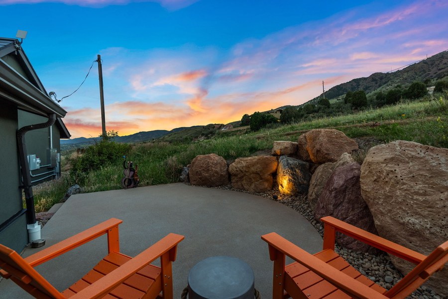 Guesthouse patio at sunset with orange chairs facing red boulders and the foothills