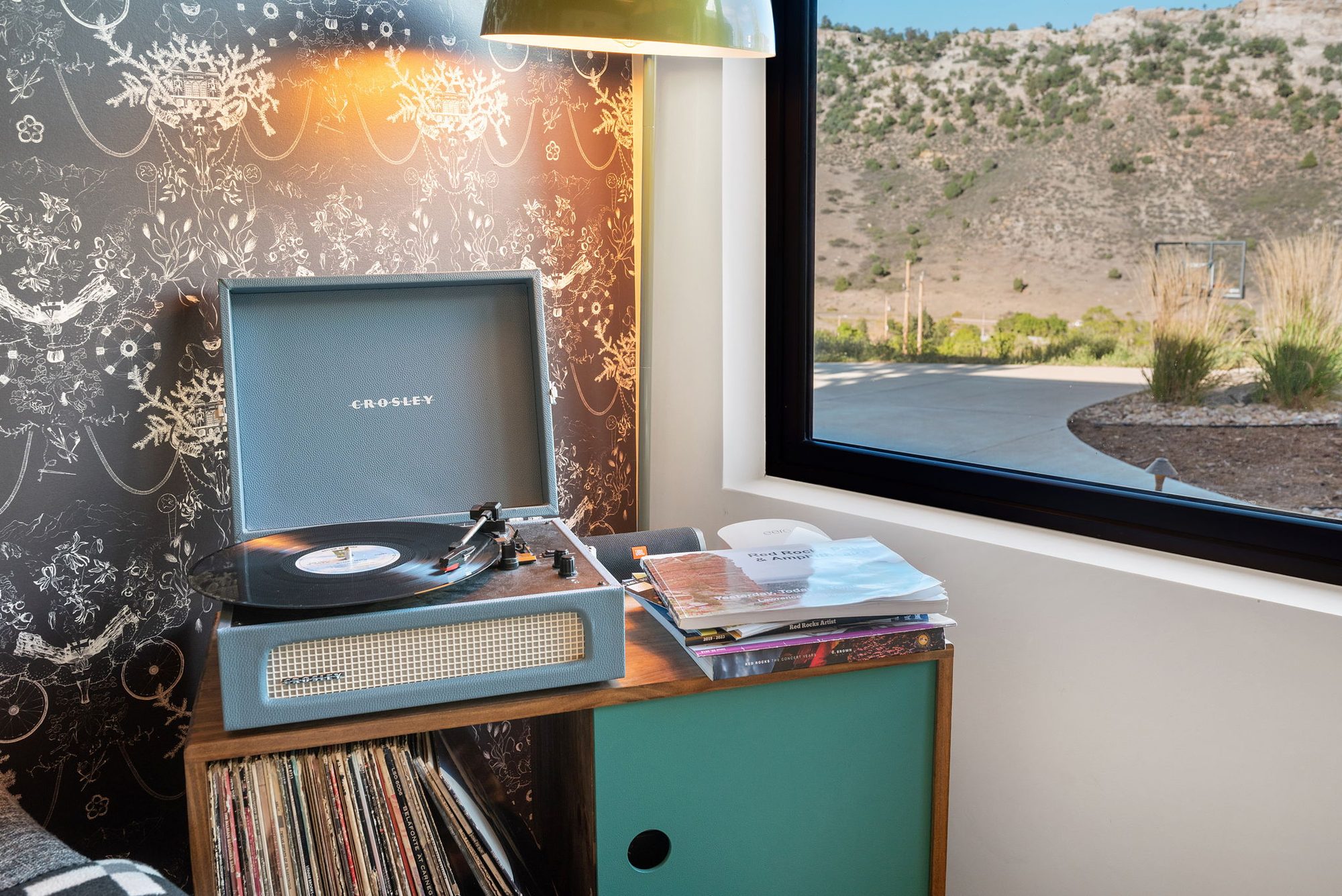 Guesthouse turntable and records against dark patterned wallpaper