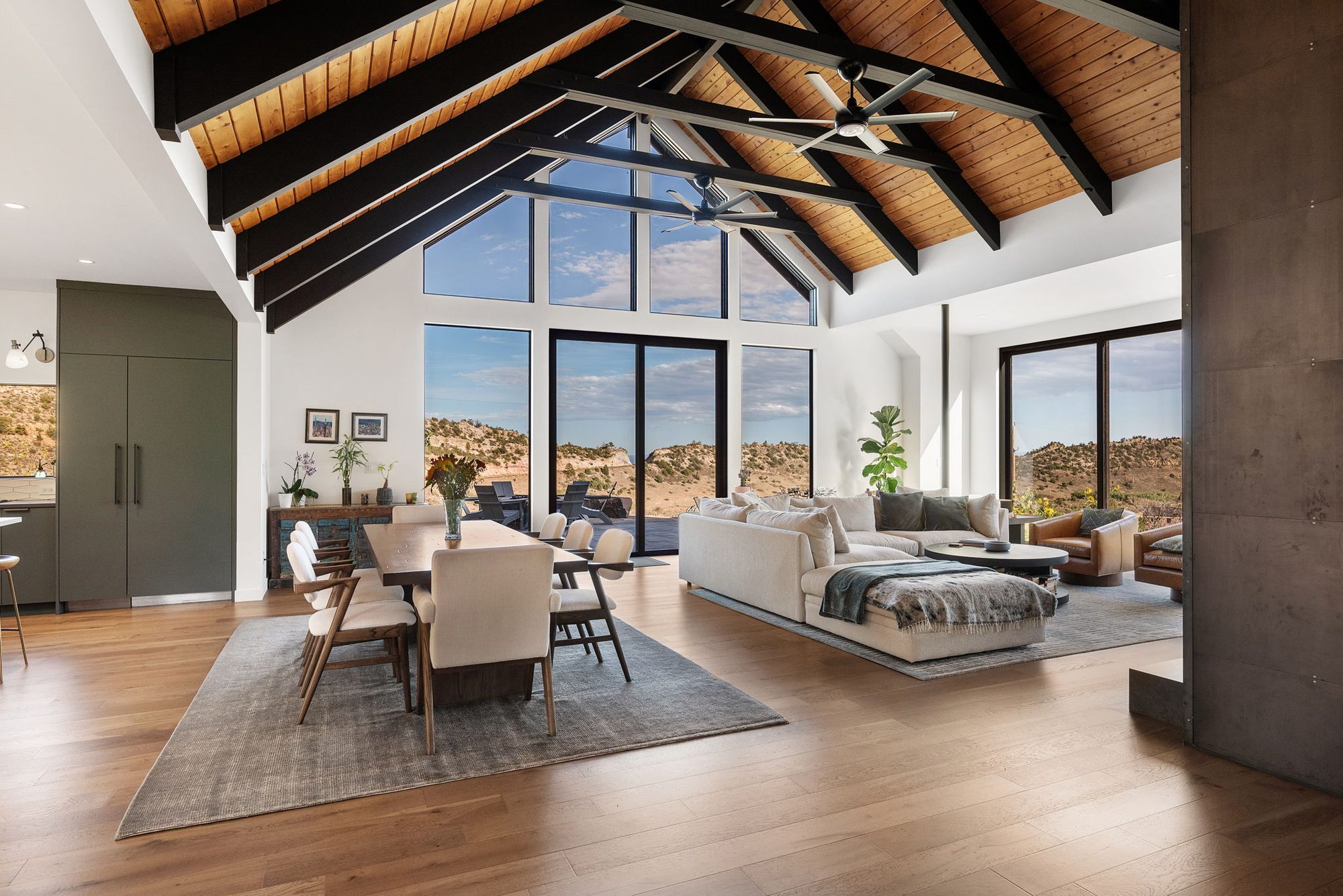 Great room with vaulted timber ceiling, black-framed windows and mountain views