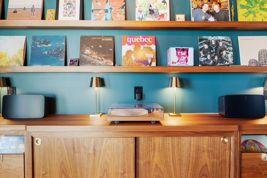 Record shelves above a walnut credenza with a turntable in the Music Lounge