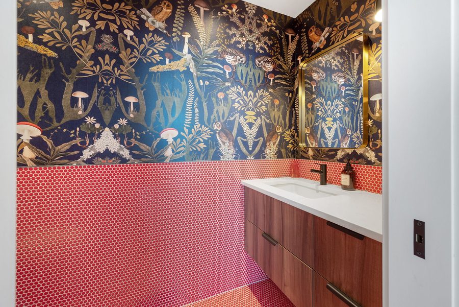 Powder room with patterned wallpaper and pink tile