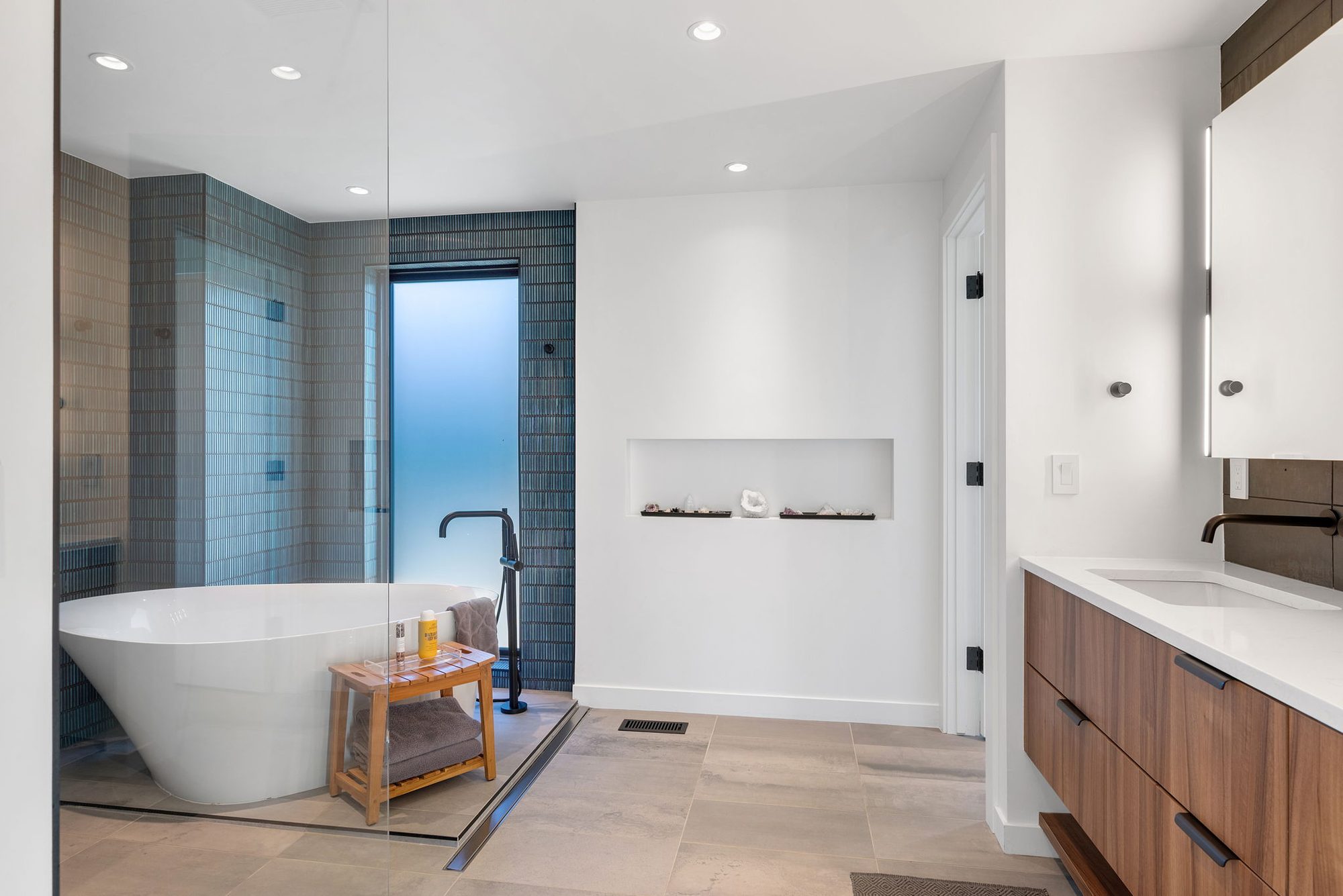 Primary bath with a freestanding tub beside a glass-enclosed wet room
