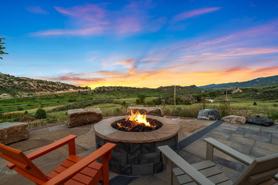 Fire pit burning at sunset with a view across the valley