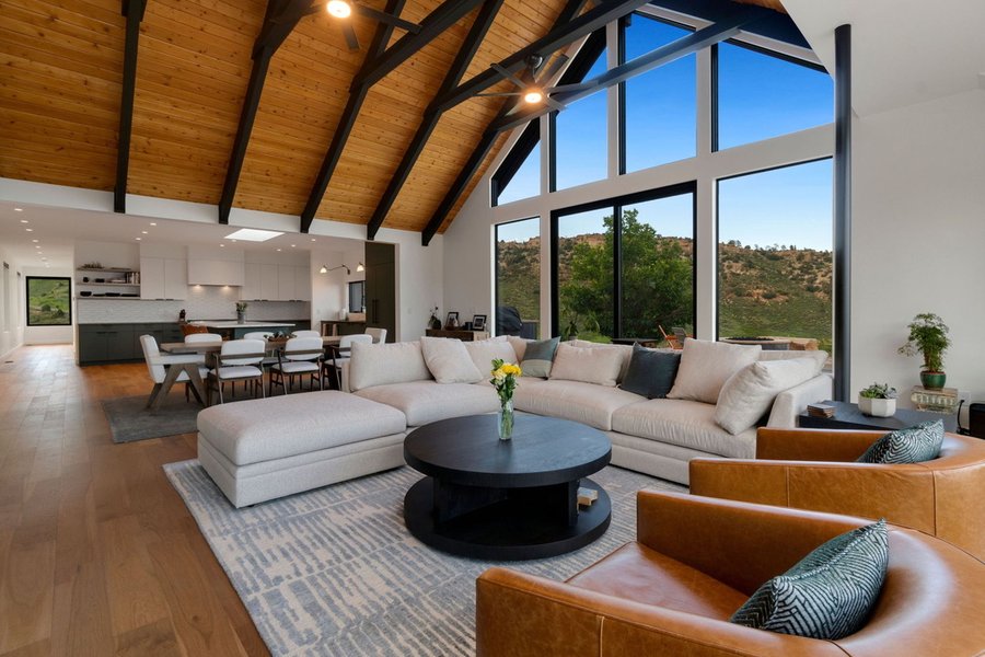 Great room with steel beams, tall windows and a view of the foothills